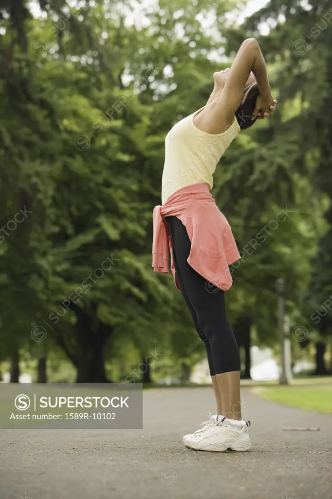 Side view of woman stretching in park