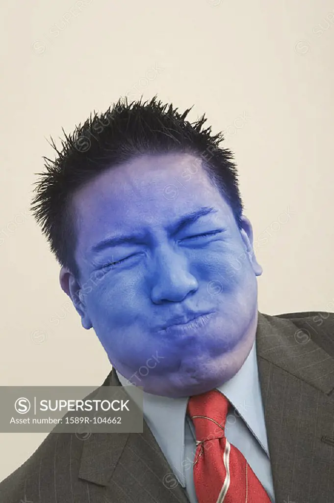 Young businessman holding breath and turning blue