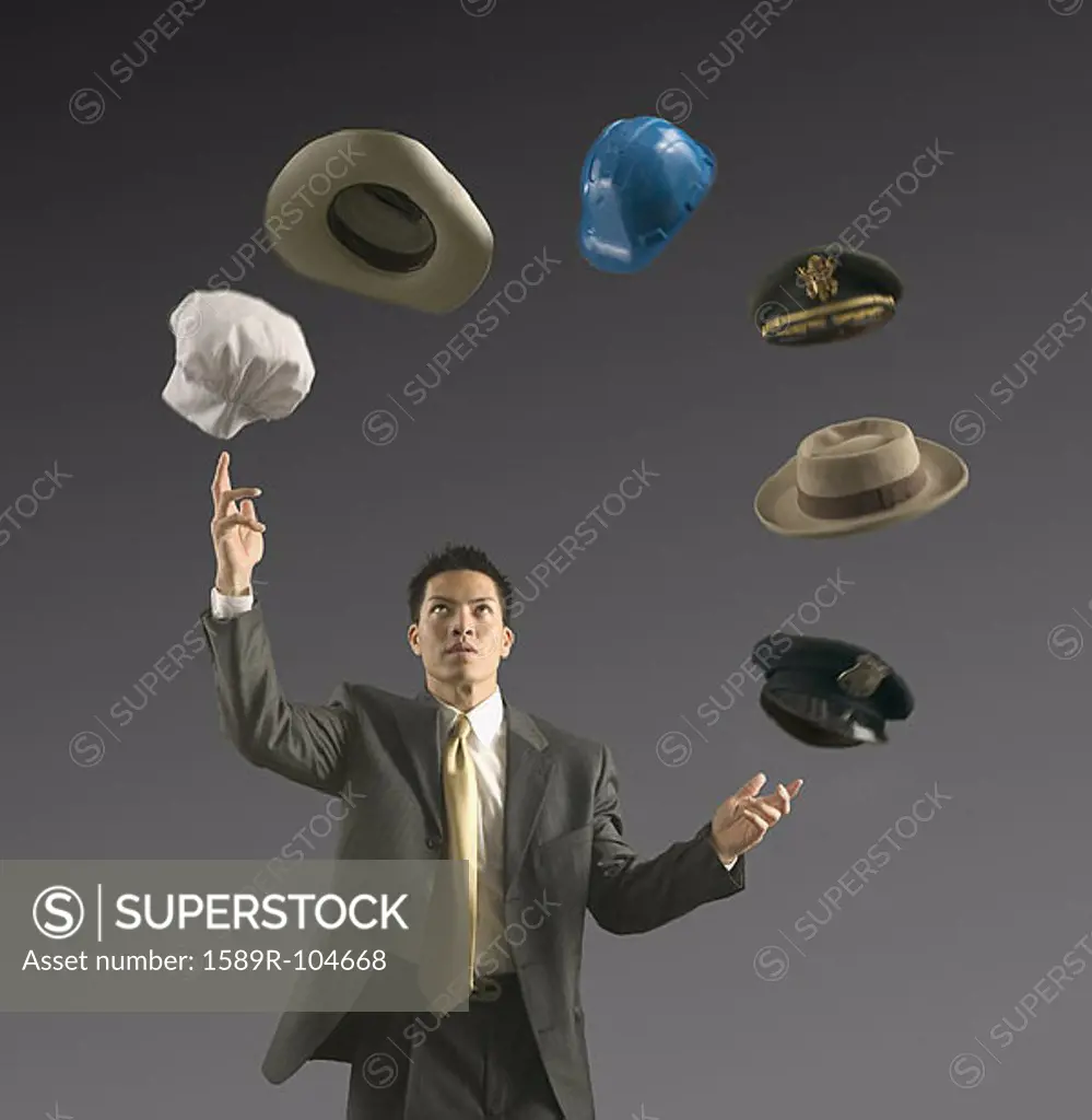 Young businessman juggling six hats