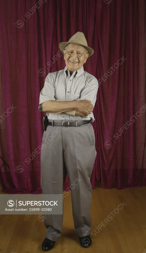 Elderly man standing with arms crossed