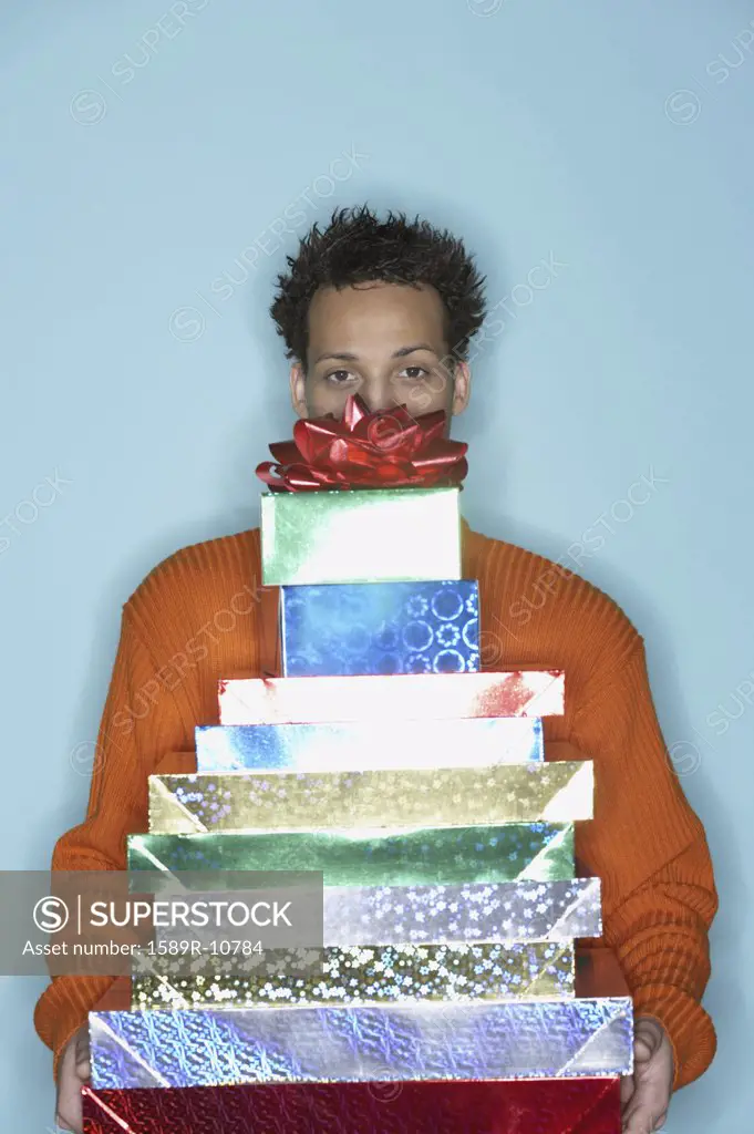 Young man behind stack of gifts