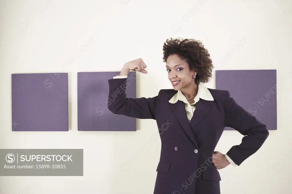 Businesswoman flexing her bicep