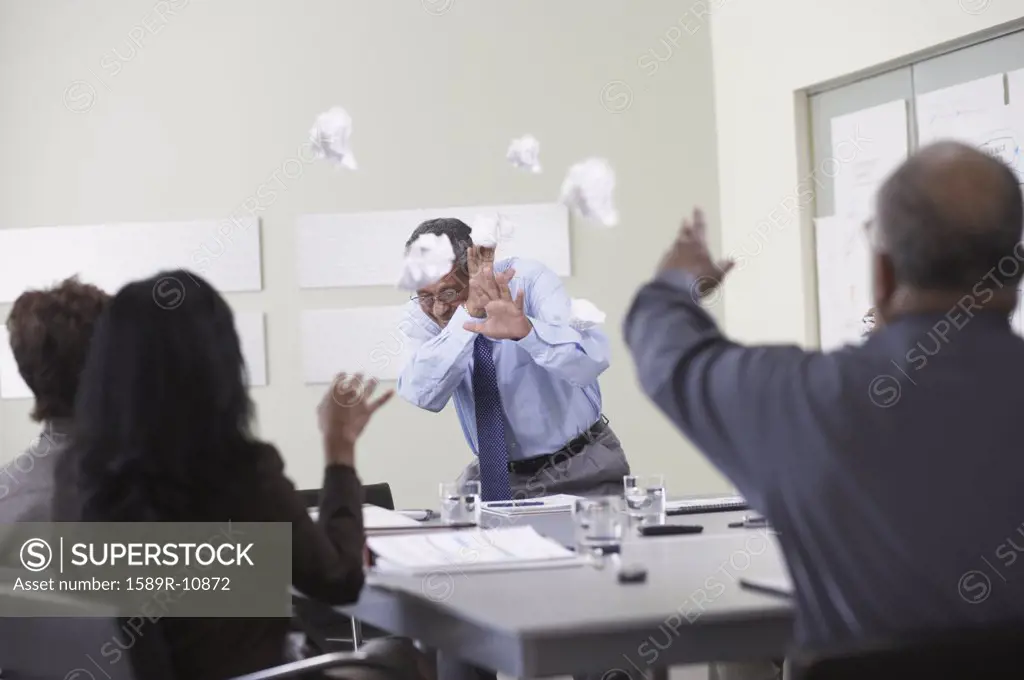 Businesspeople throwing paper balls