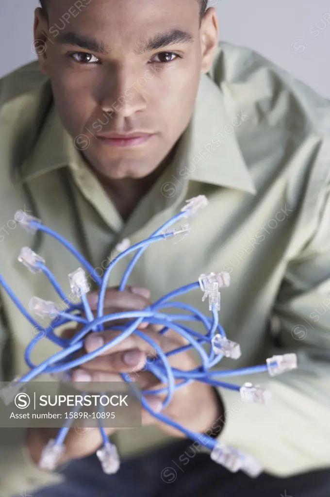 Young man holding Ethernet cables