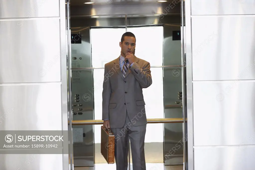 Young businessman inside elevator