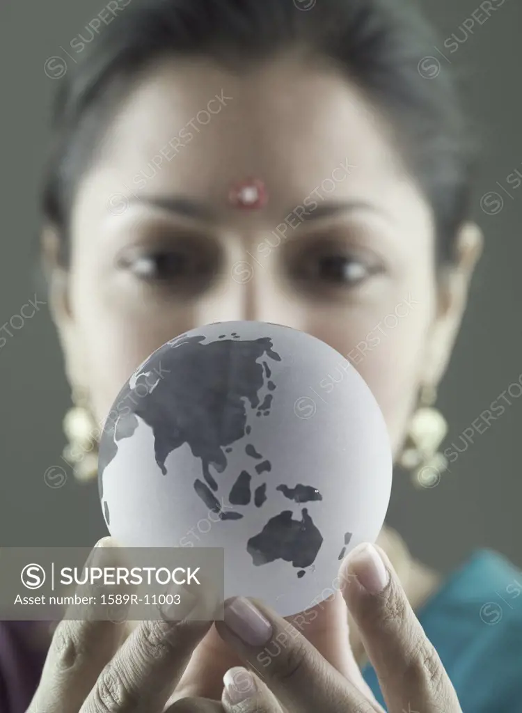 Portrait of a mid adult woman holding a globe