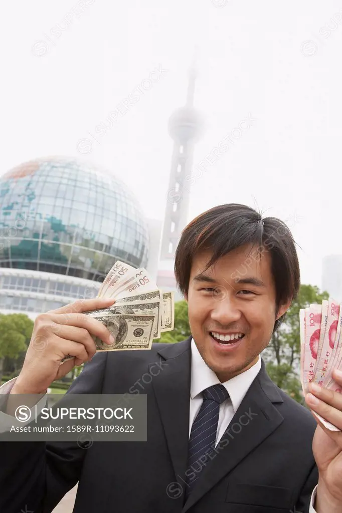 Chinese businessman holding wads of money, Shanghai, China