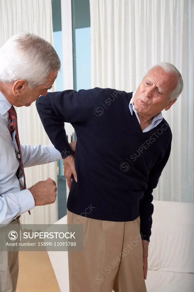 Senior man seeing doctor about back pain