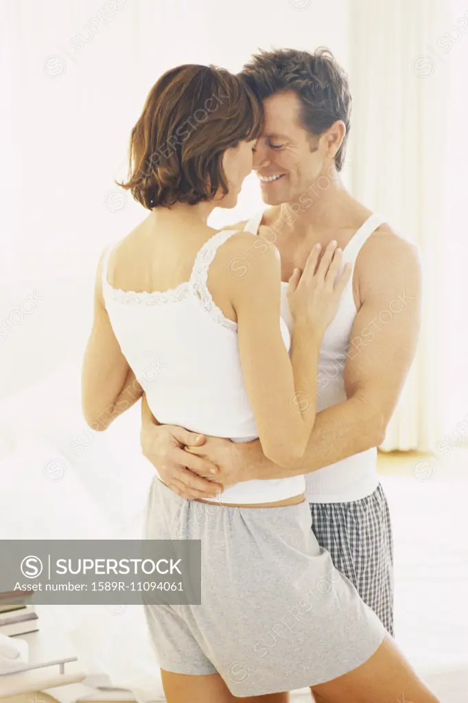 Couple hugging in bedroom