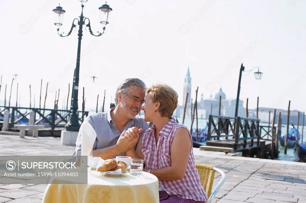 Senior couple eating at sidewalk cafe, Venice, Veneto, Italy