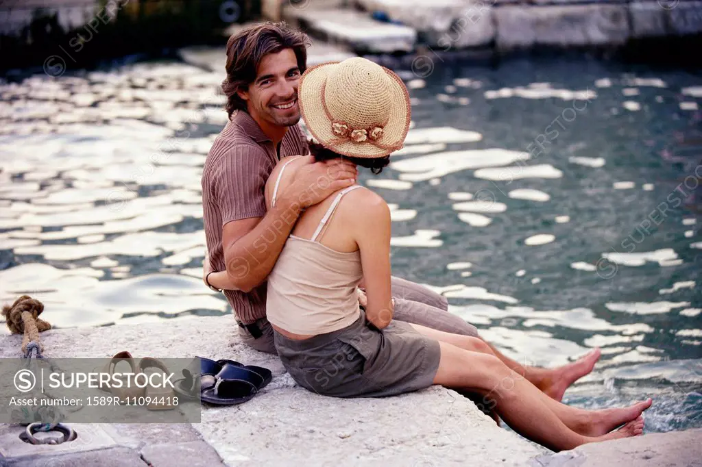 Caucasian couple sitting together by canal