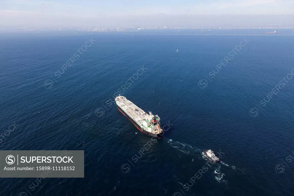 Oil tanker with tugboat at sea