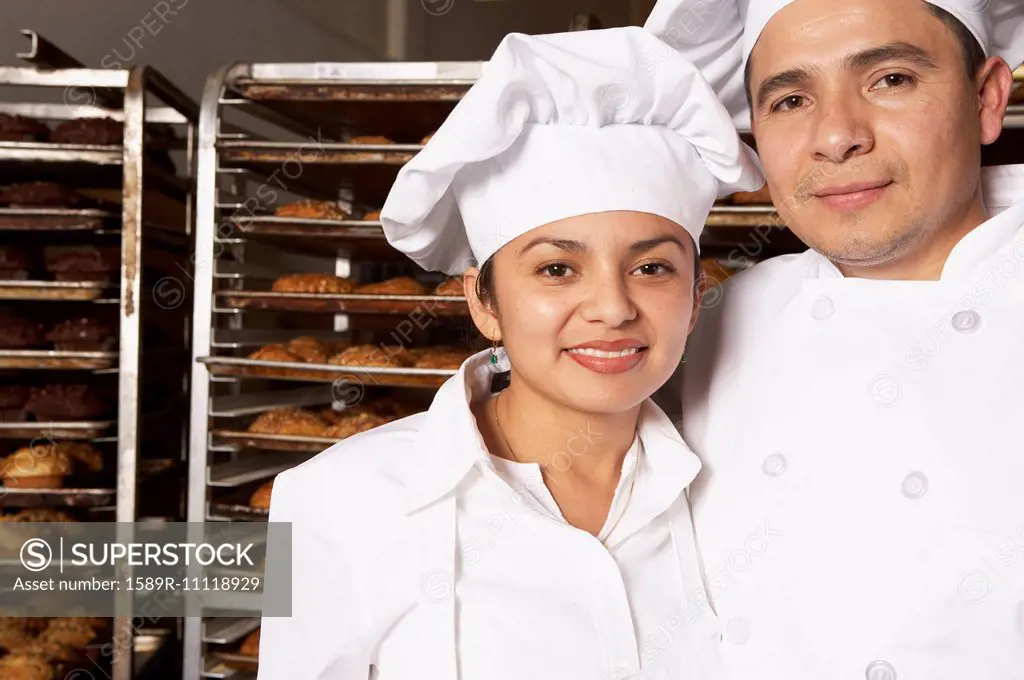Hispanic bakers smiling in bakery