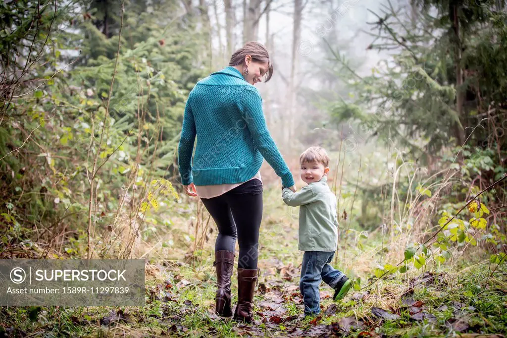 Caucasian mother and son walking in forest