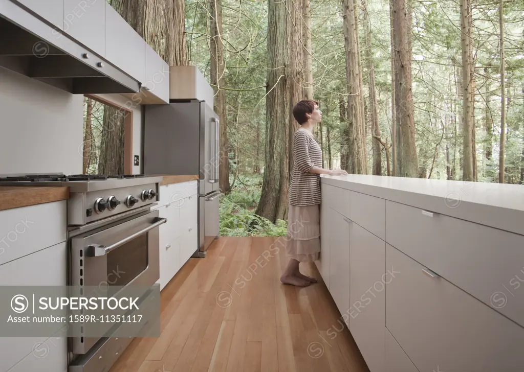 Woman standing in kitchen in forest