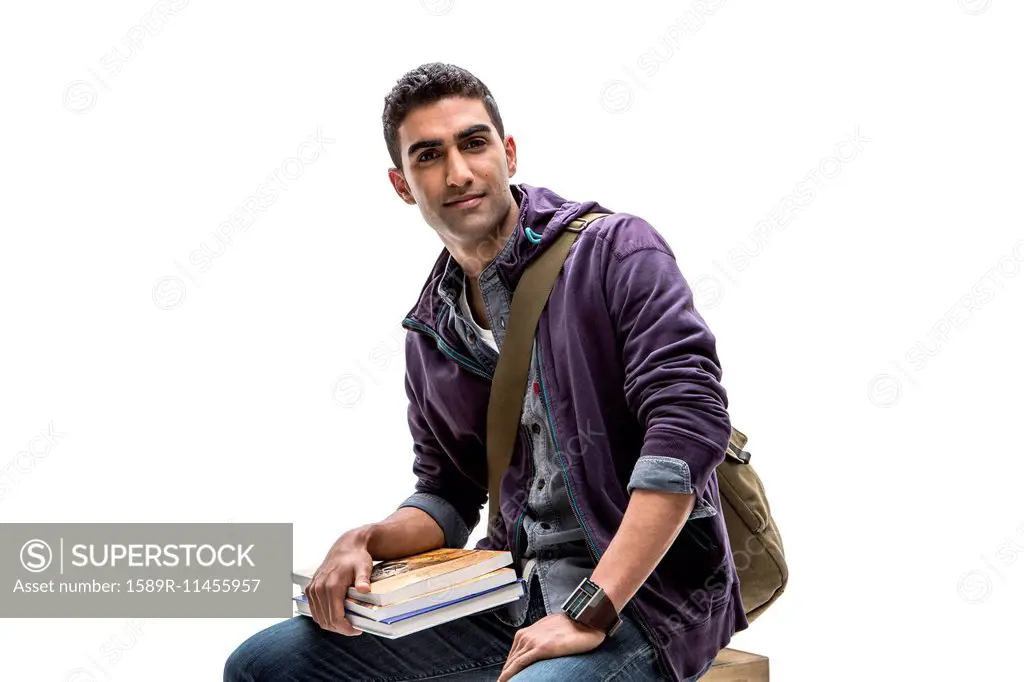 Indian student holding stack of books
