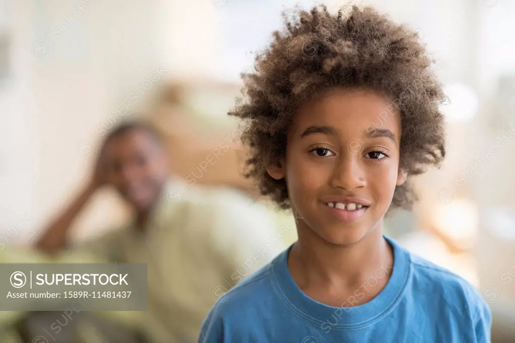 Mixed race boy smiling in living room