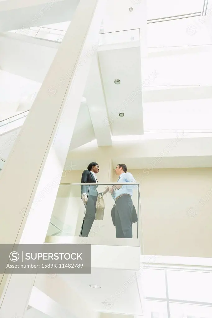 Low angle view of business people talking on office balcony