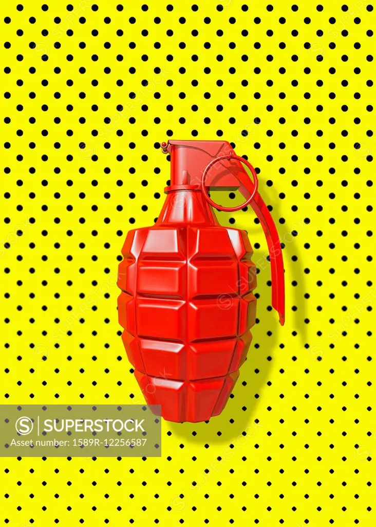 Close up of red grenade on polka dot background