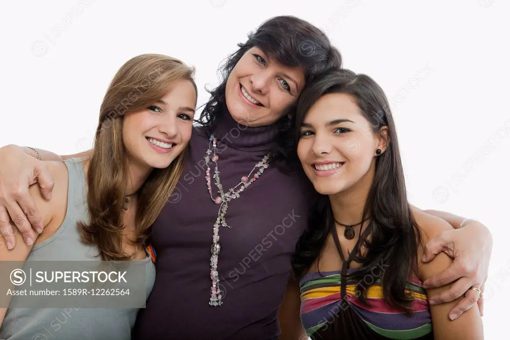 Hispanic mother hugging daughters