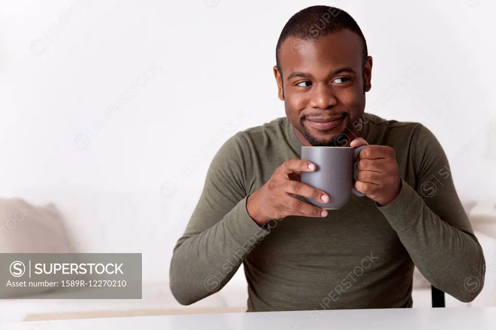 Smiling Black man drinking coffee