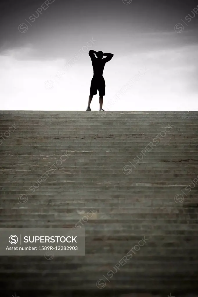 Black man stopping at top of stairs