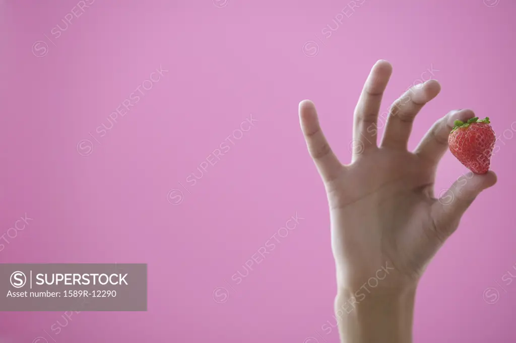 Closeup of hand holding a strawberry