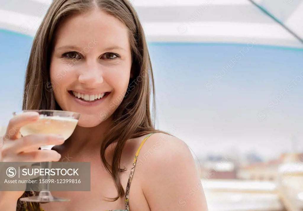 Caucasian woman drinking cocktail outdoors