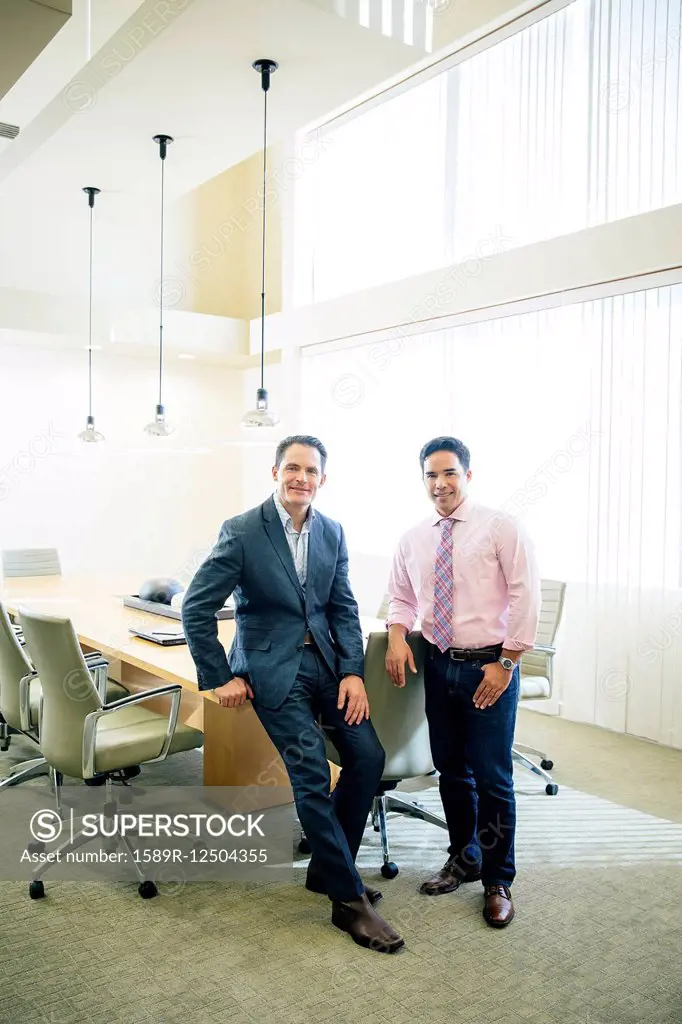 Mixed race businessmen smiling in office meeting