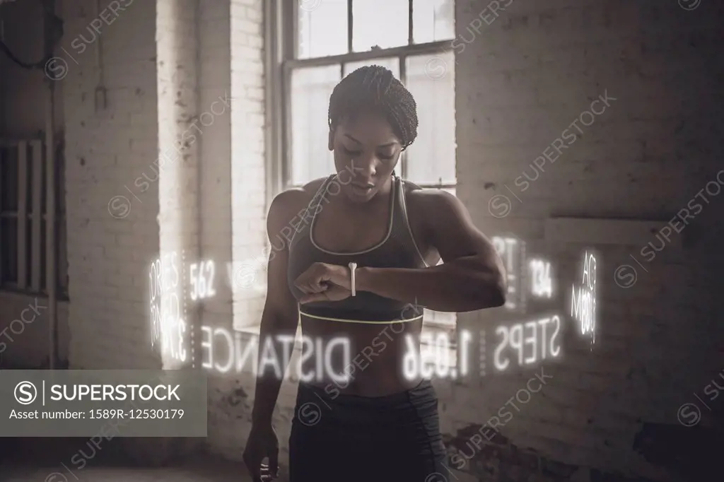 Virtual words circling Black athlete checking fitness tracker
