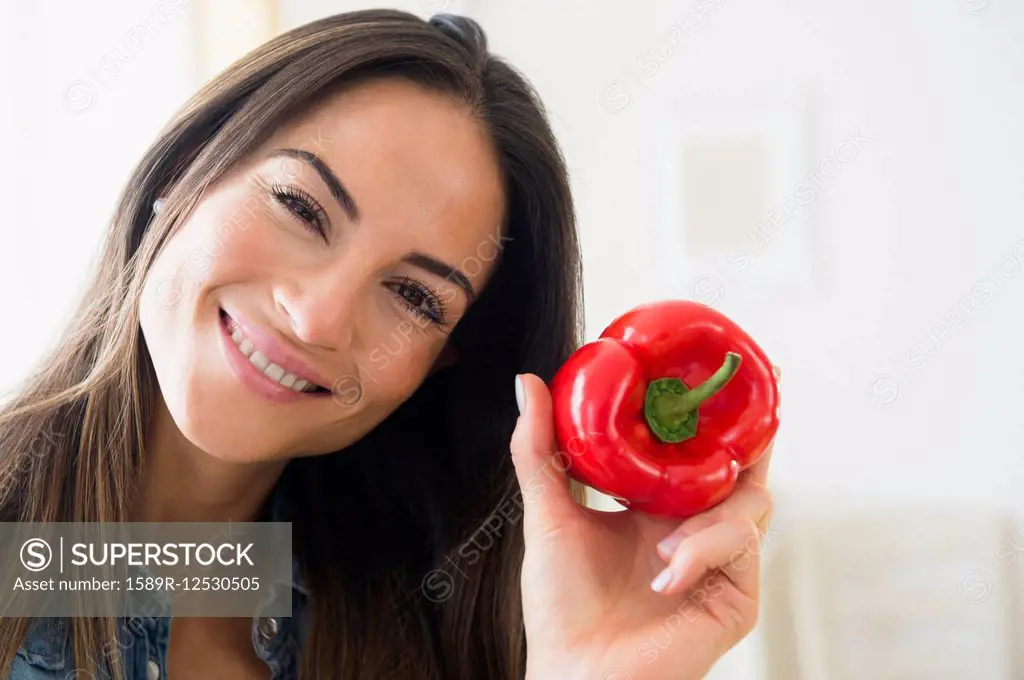 Smiling Caucasian woman holding red pepper