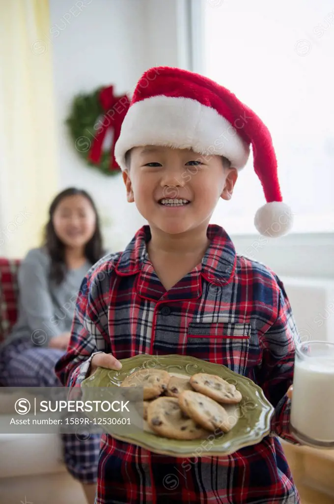 Asian boy holding plate of cookies for Santa