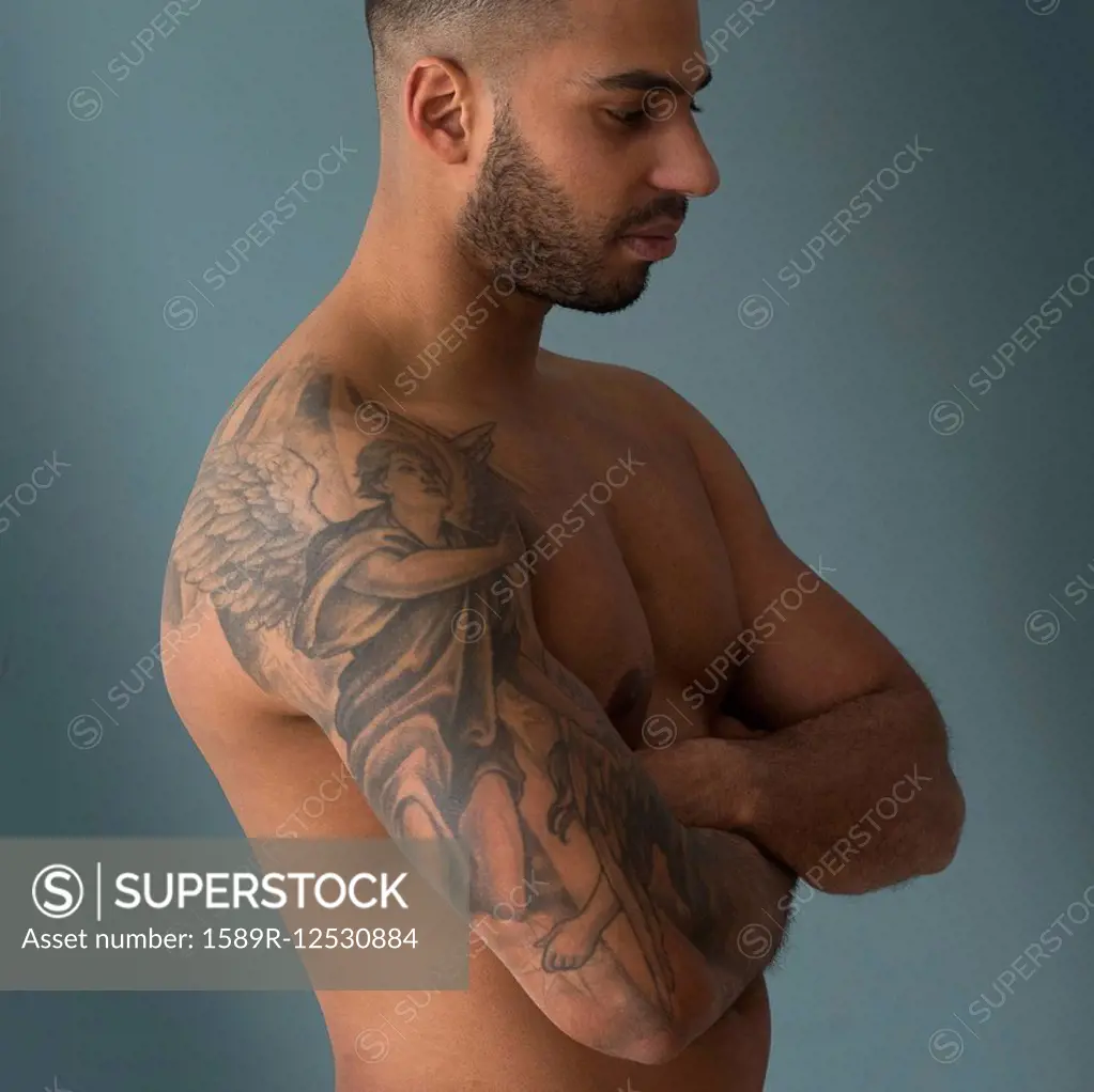 Shirtless Hispanic man with tattoos