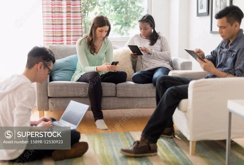Friends using technology in living room