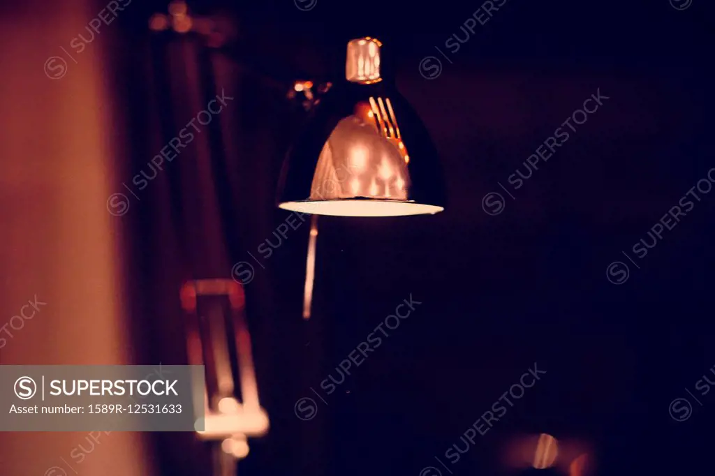Close up of illuminated desk lamp at night