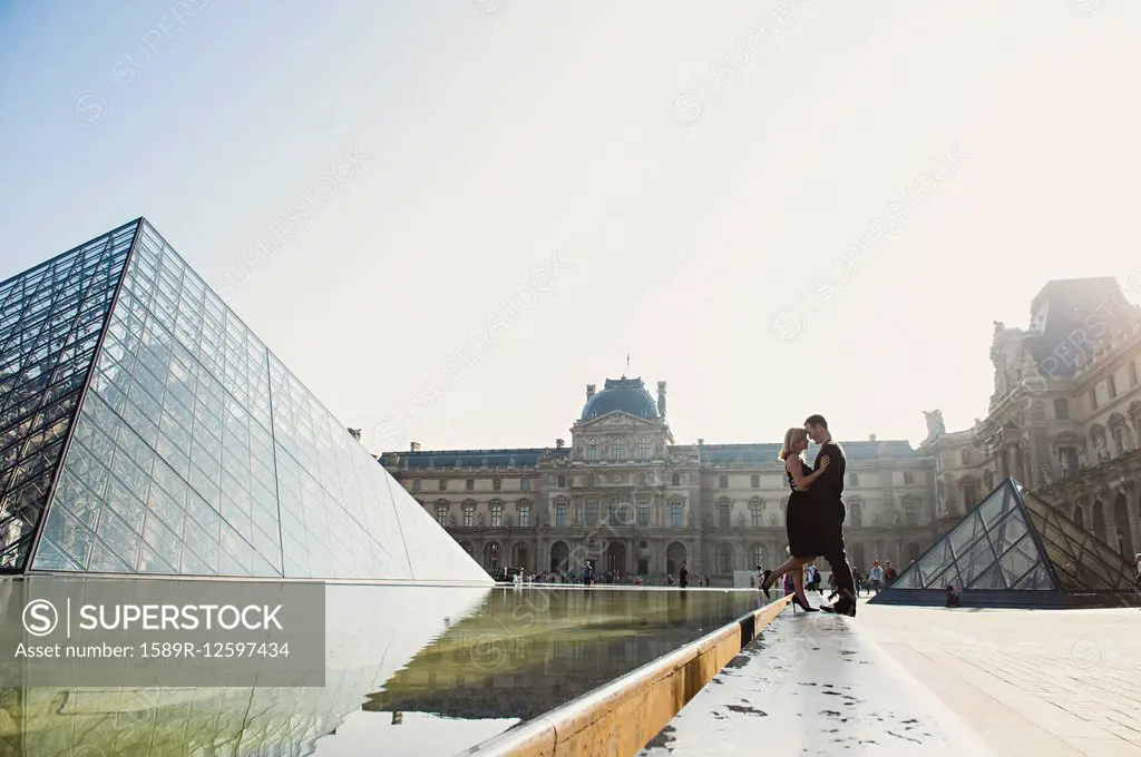 Caucasian couple kissing near ornate building, Paris, Ile-de-France, France