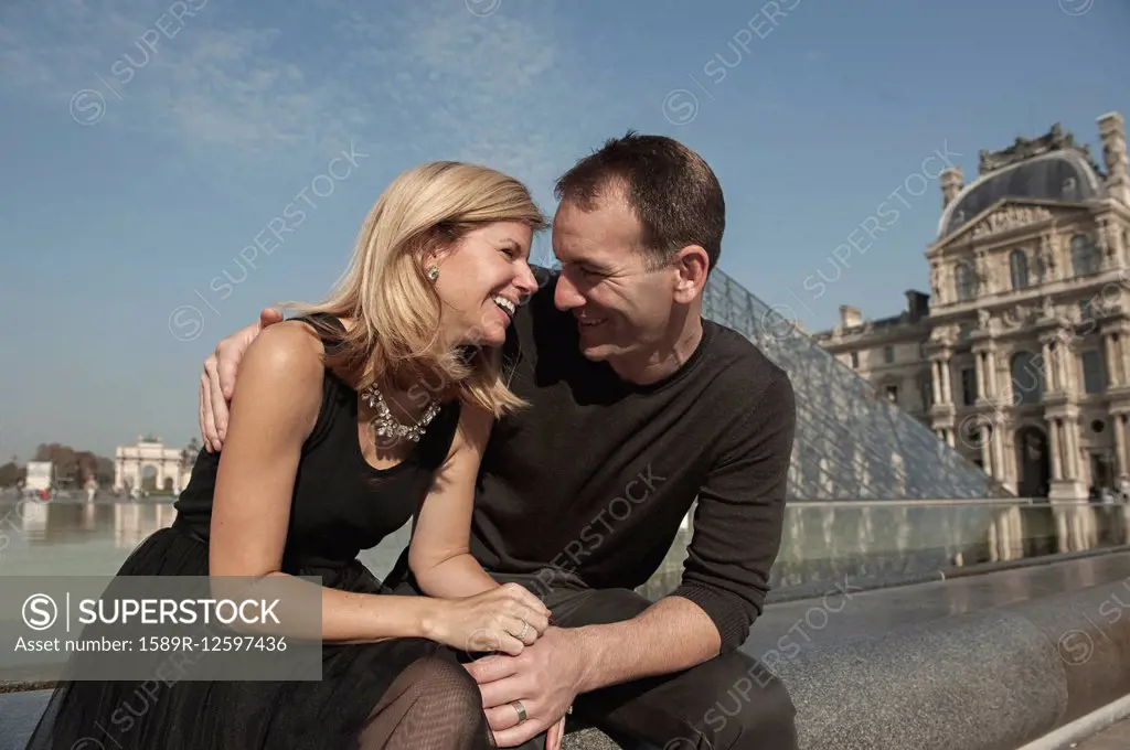 Caucasian couple laughing near fountain, Paris, Ile-de-France, France
