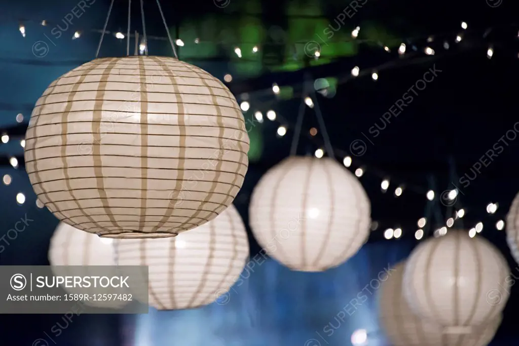 Close up of paper lanterns and string lights at night