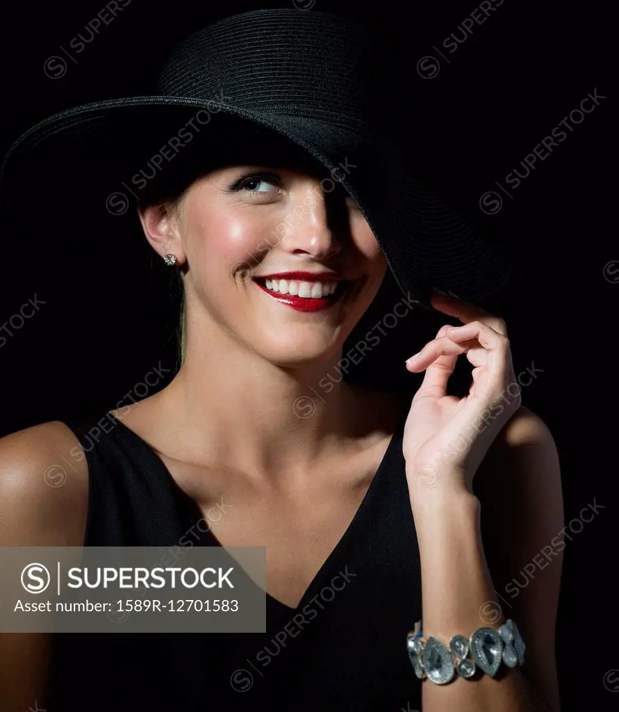 Stylish Caucasian woman wearing black hat and dress