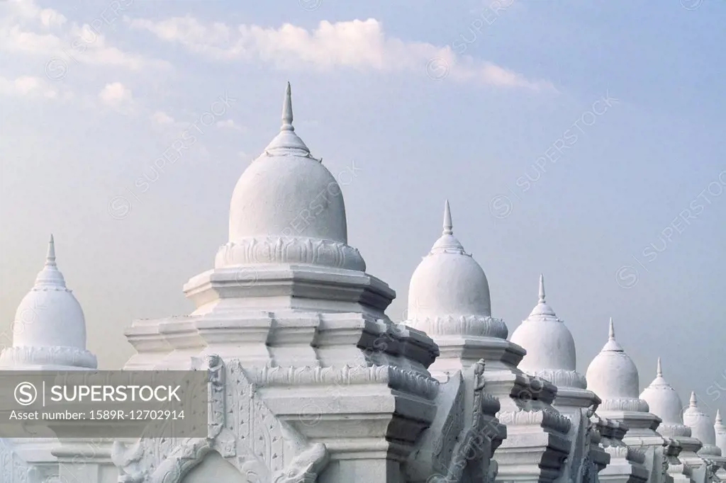 Ornate domes under cloudy sky, Mandalay, Myanmar