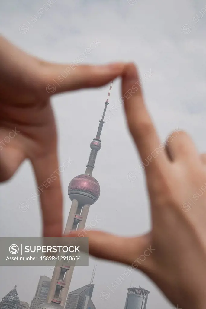 Chinese woman framing Shanghai tower, Shanghai, China