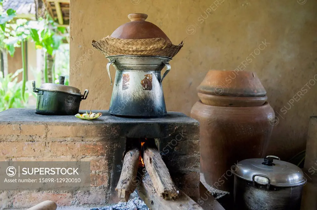 Pots cooking food over wood stove in outdoor kitchen
