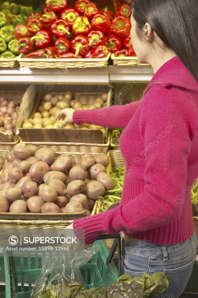 Side profile of a young woman taking vegetable