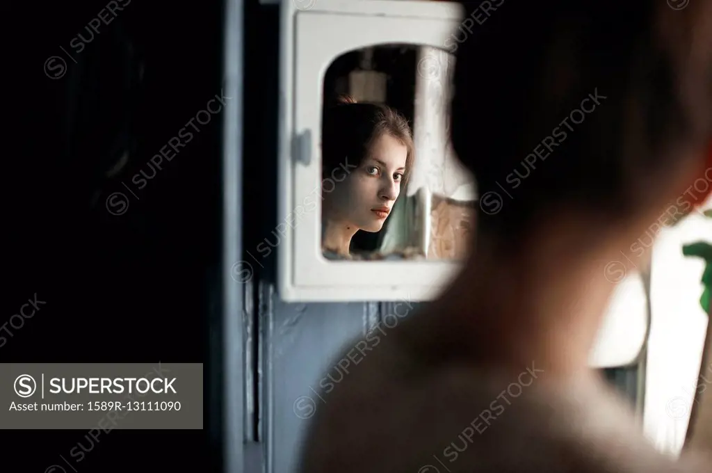 Caucasian woman admiring herself in mirror