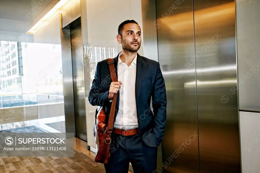 Caucasian businessman waiting for office elevator