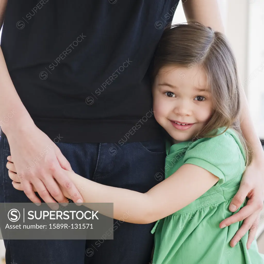Mixed race girl hugging mother