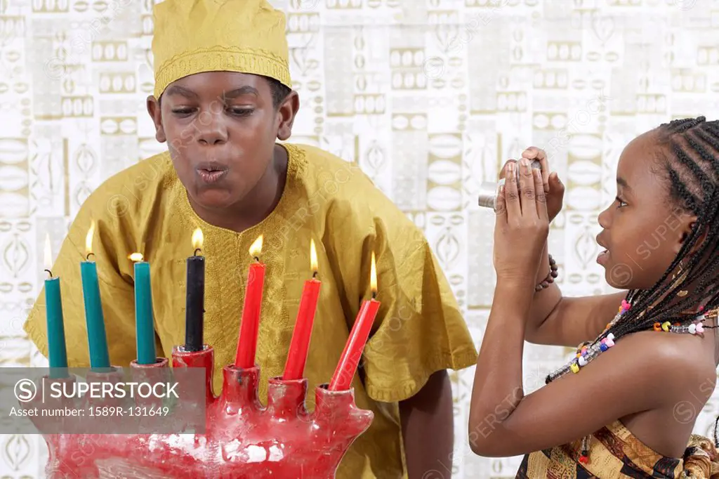 African American boy blowing out Kwanzaa candles