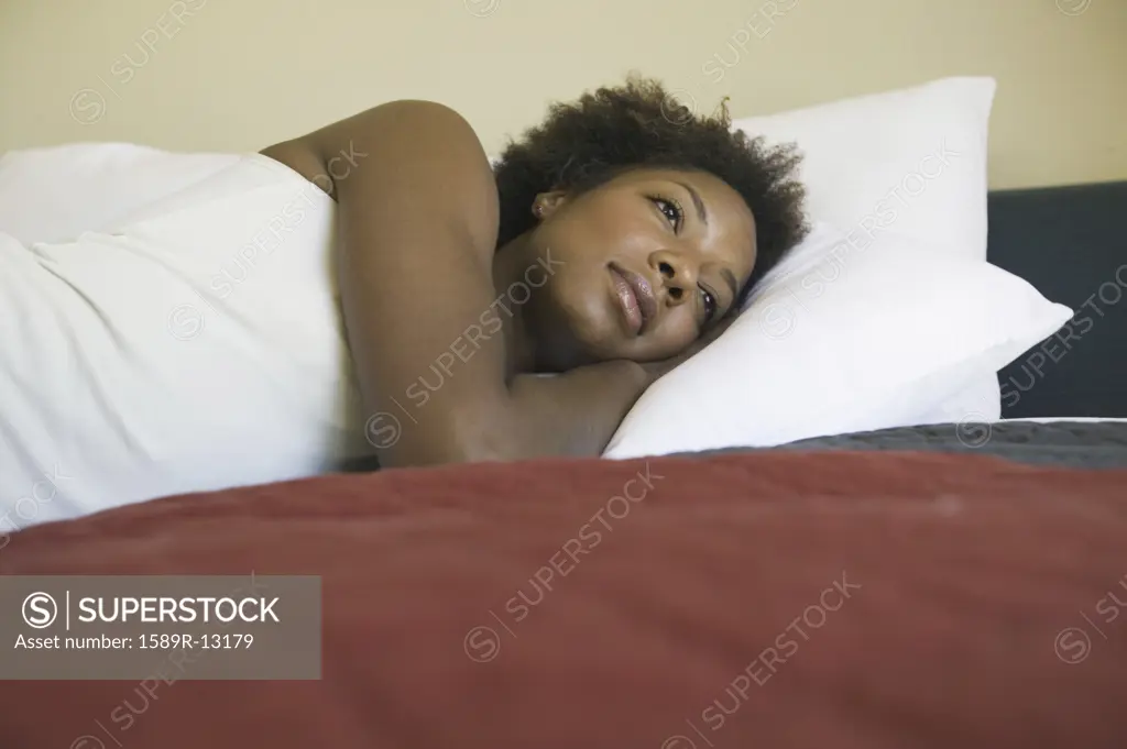 Moody young woman resting on her bed