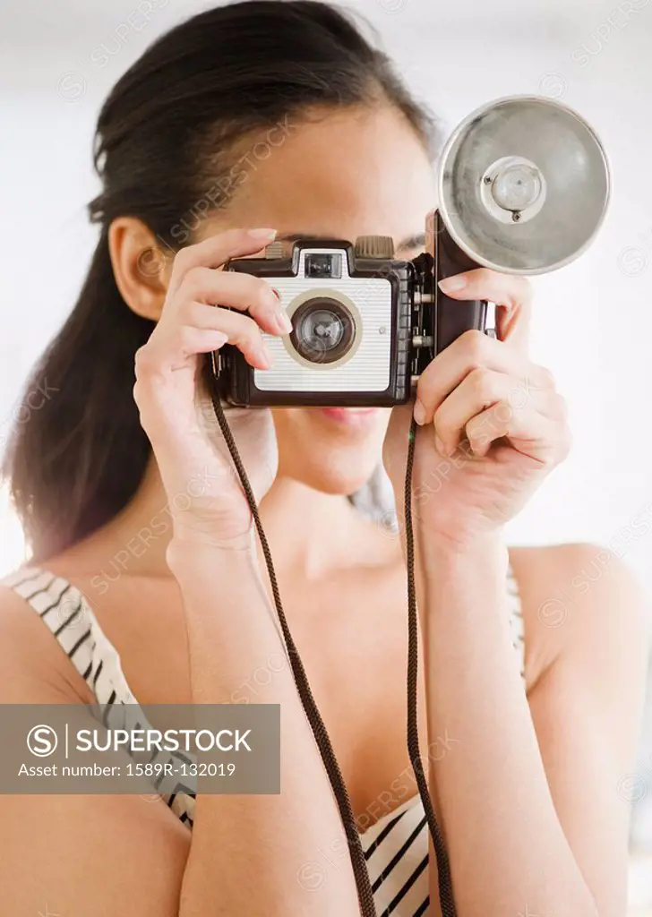 Mixed race woman using old_fashioned camera