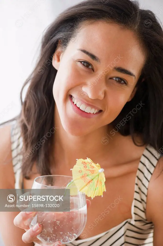 Mixed race woman drinking cocktail